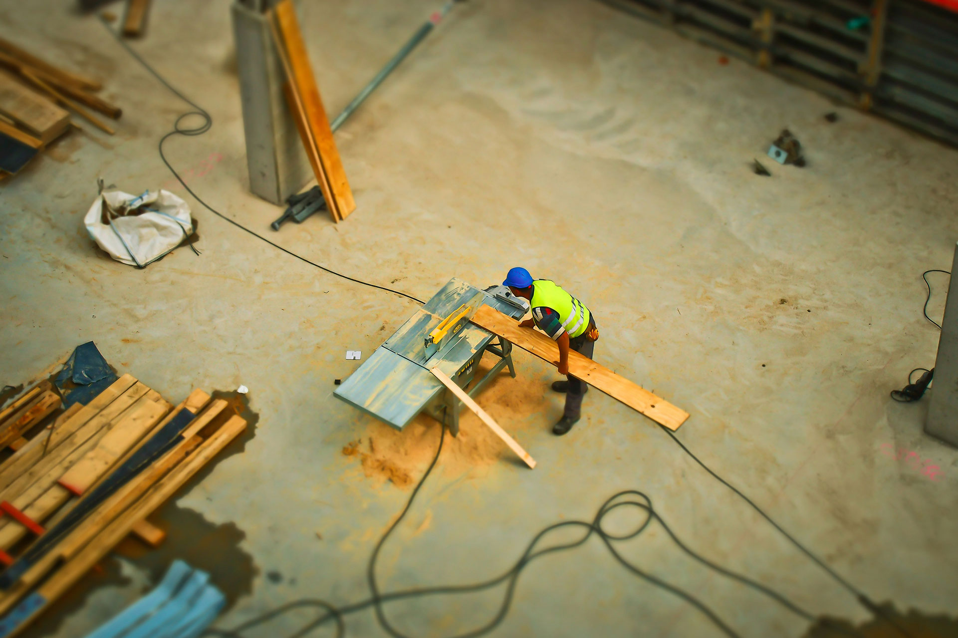 worker operating woodwork machine on a construction site